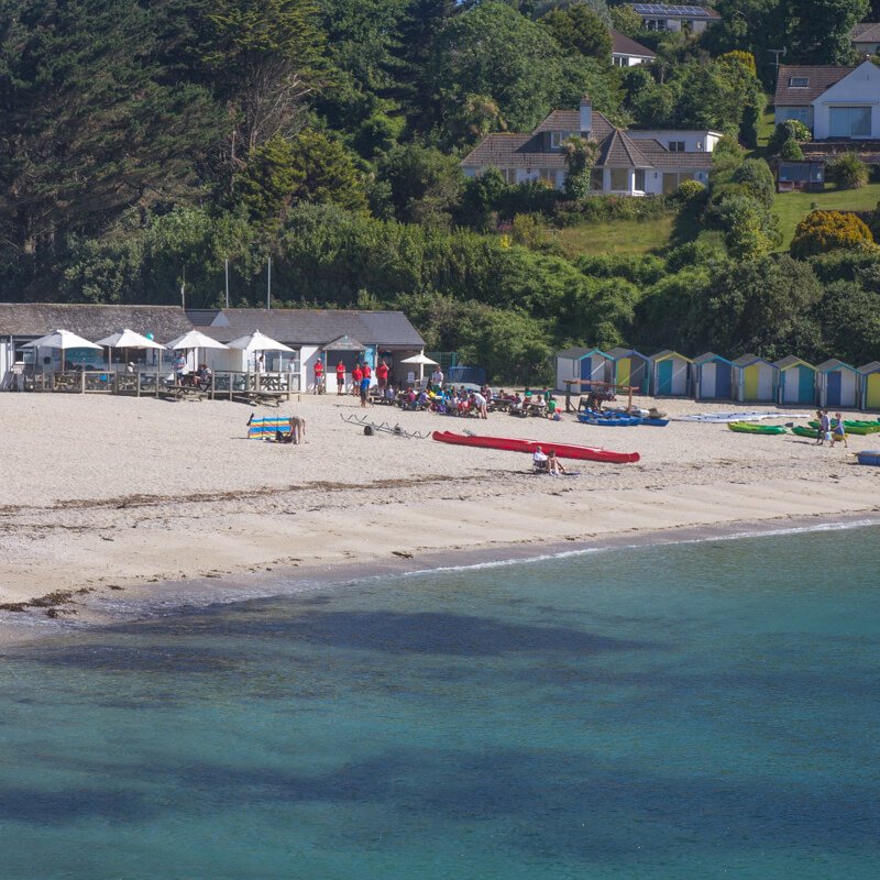 Swanpool Beach from the water with the beach, cafe and beach huts in the background